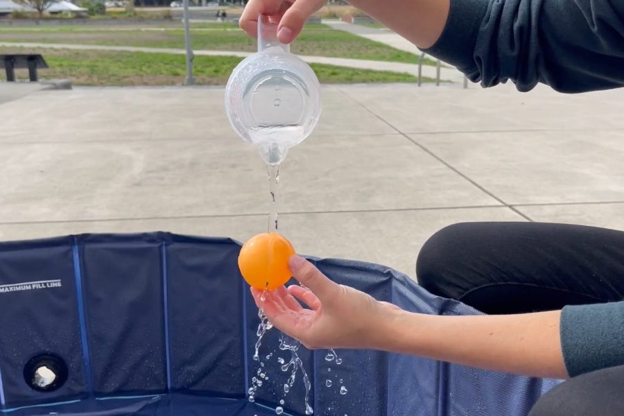 Water being poured over small orange sphere